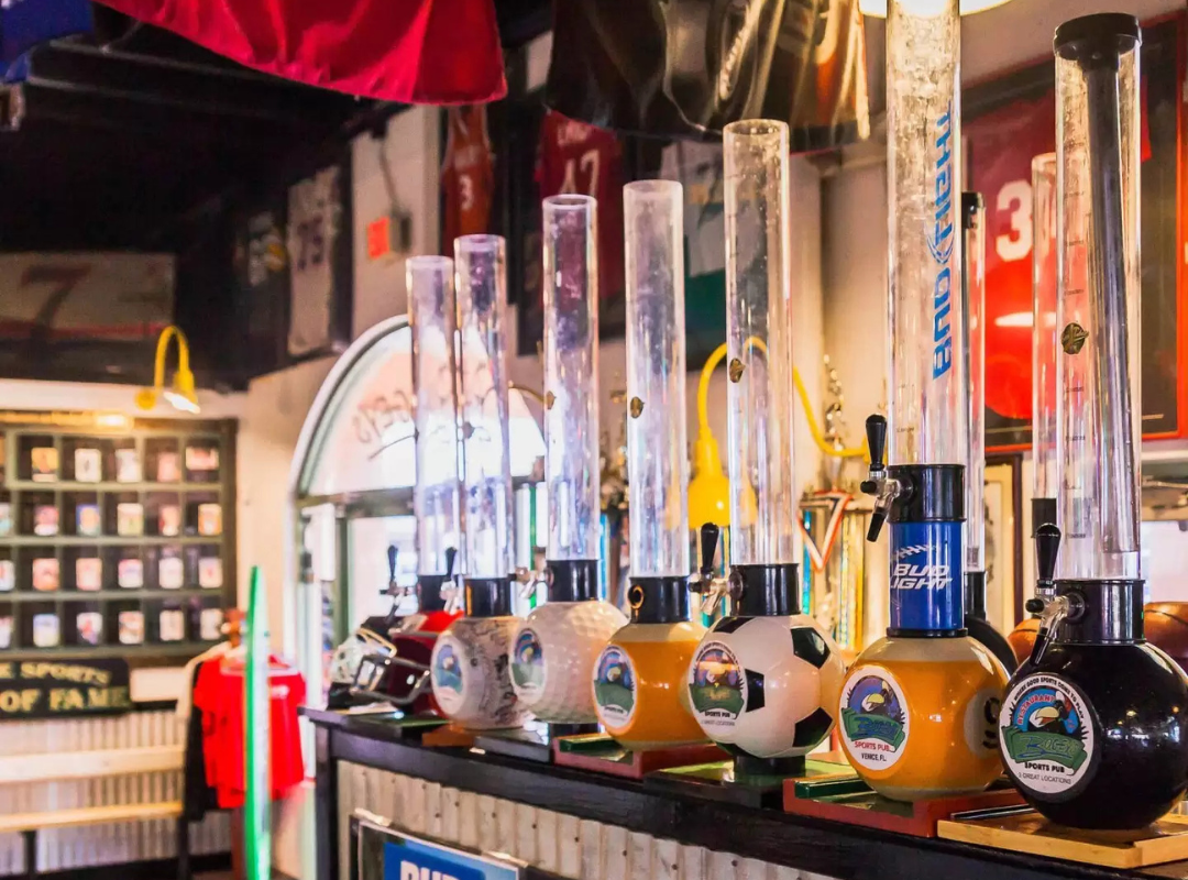 Sports-themed draft beer towers and tap handles lining the bar at Bogey's Sports Pub in Venice, FL with sports memorabilia displayed throughout